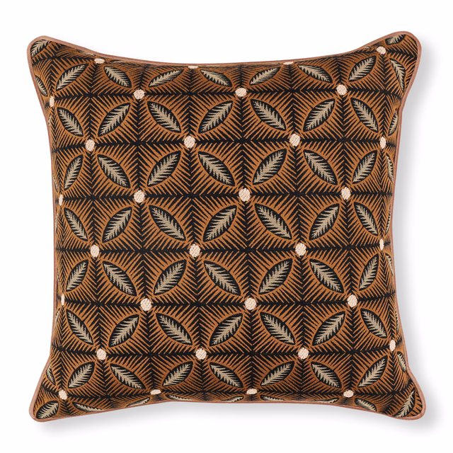 Warm sienna cushion fabric with charcoal geometric leaves and pale cream accents