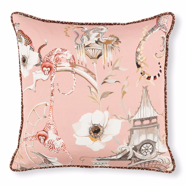 Blush-pink fabric with exotic animals, flowers and architectural scenes on a boudoir cushion
