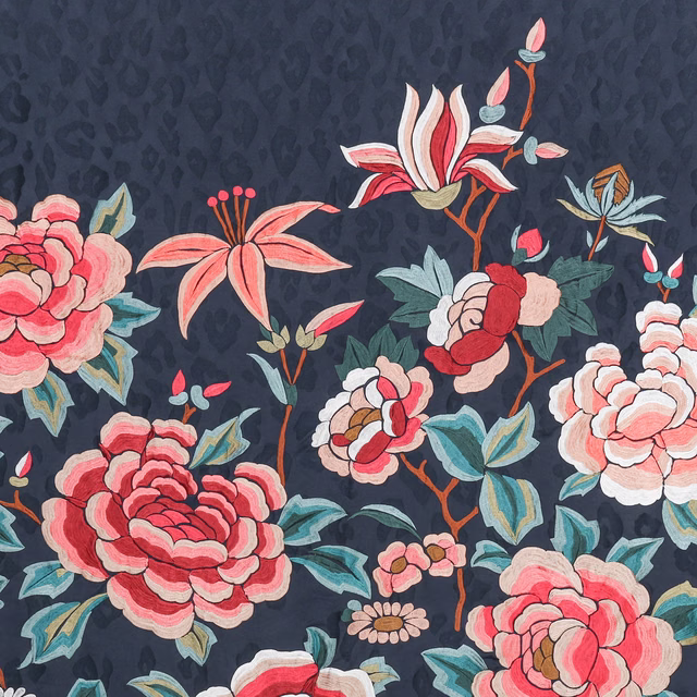 Large coral and cream flowers with teal leaves on a deep navy floral fabric
