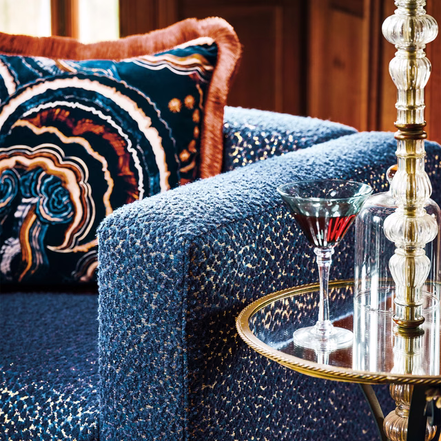 Deep indigo-blue nubby upholstery with pale flecks on a rounded chair
