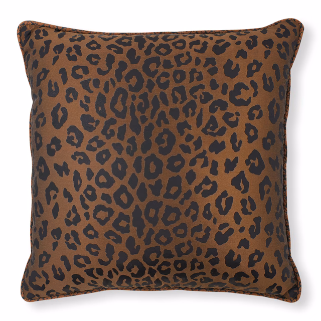 Copper-brown cushion with irregular charcoal leopard spots and a softly lustrous surface