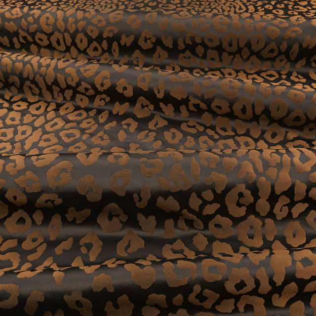 Burnished copper leopard spots across a black, softly lustrous folded fabric