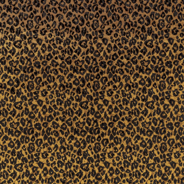 Warm amber-brown textile with dense black leopard spots and a softly textured surface