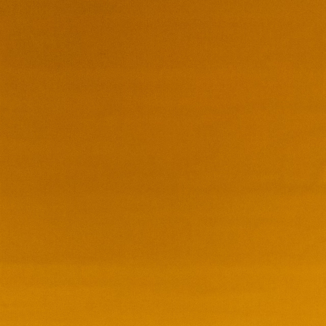 Close-up of smooth nectar-orange velvet with subtle amber shifts across the pile