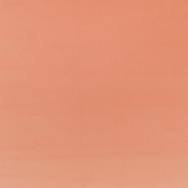 Close-up of plain coral-peach velvet with a softly brushed, subtly directional surface