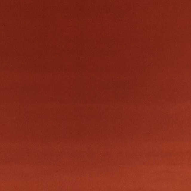 Warm russet red velvet with subtle directional nap shading across its plain surface
