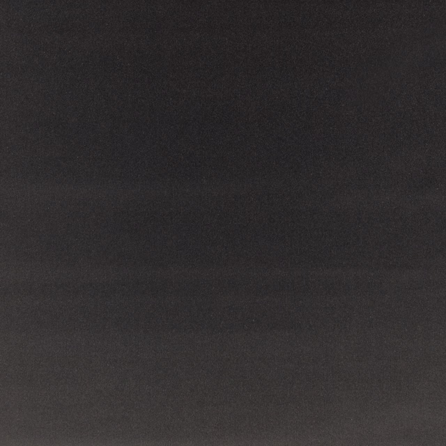 Close-up of plain charcoal slate velvet with a soft, subtly directional nap