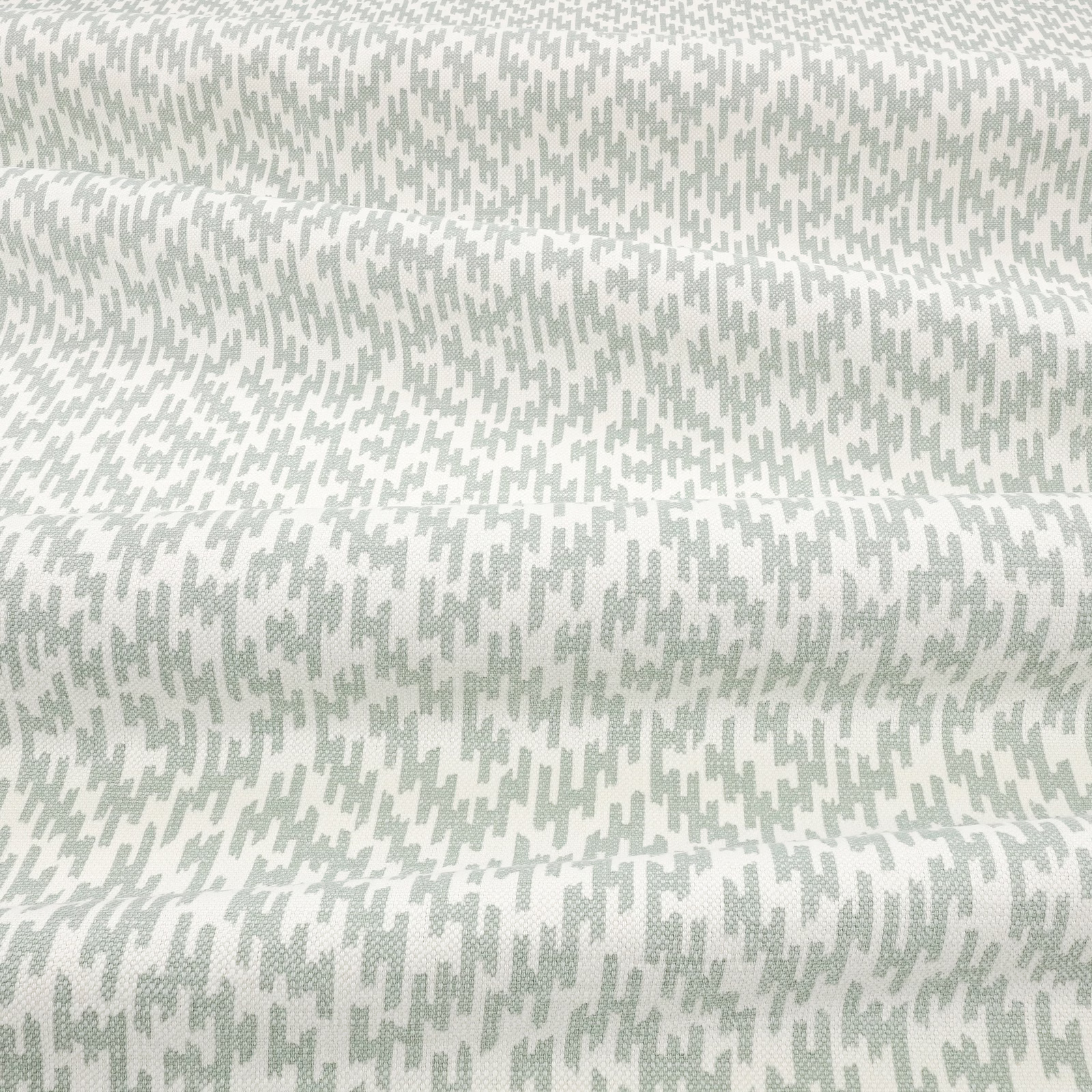 Pale mint and ivory fabric with small irregular broken marks and subtle woven texture