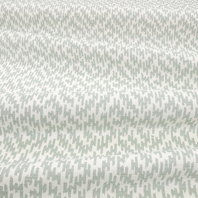 Pale mint and ivory fabric with small irregular broken marks and subtle woven texture