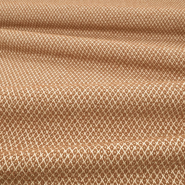 Warm ginger-brown woven fabric with cream diamond lattice and raised tactile texture