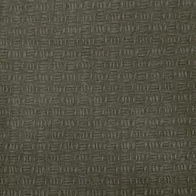 Close-up of muted olive-brown woven fabric with small repeating textured blocks