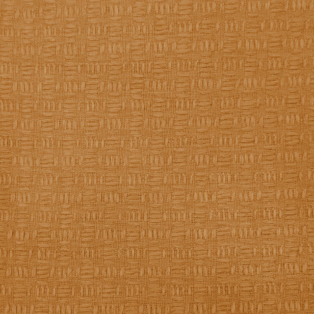 Close-up of warm orange textured fabric with a small woven geometric pattern