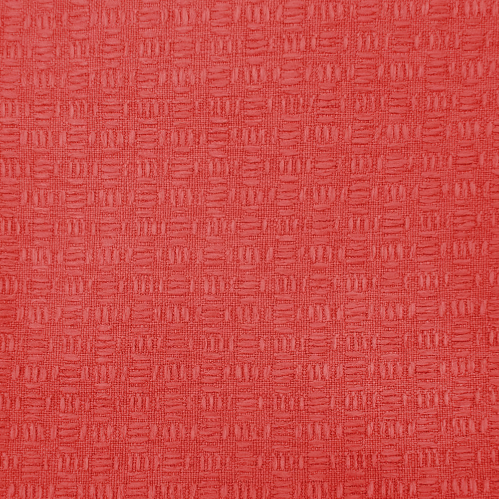 Close-up of bright coral-red woven fabric with small geometric texture