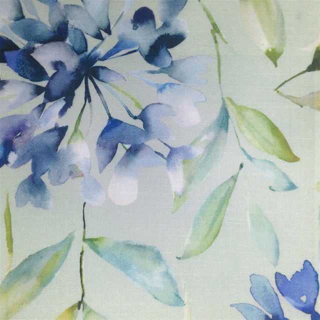 Watercolour blue floral fabric with pale green leaves on a light ground