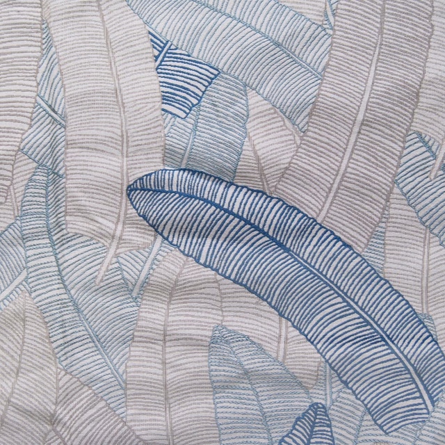 Abstract blue leaf-pattern fabric swatch on a pale textured ground