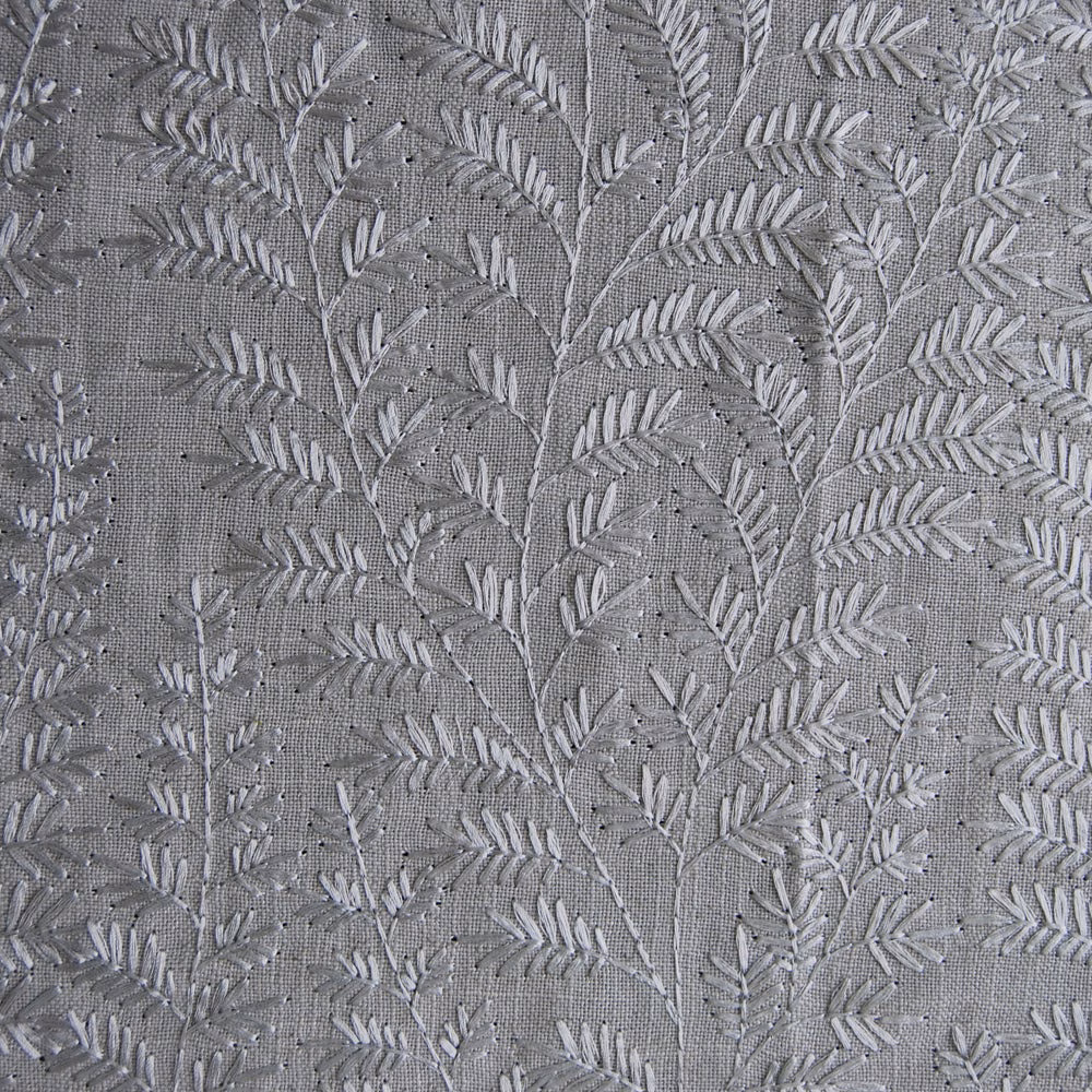 Close-up of grey botanical fern embroidery on a linen-look fabric ground