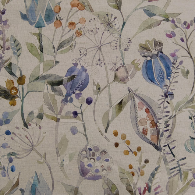 Painterly botanical fabric with soft blue flowers, lilac accents and leafy stems on a pale ground
