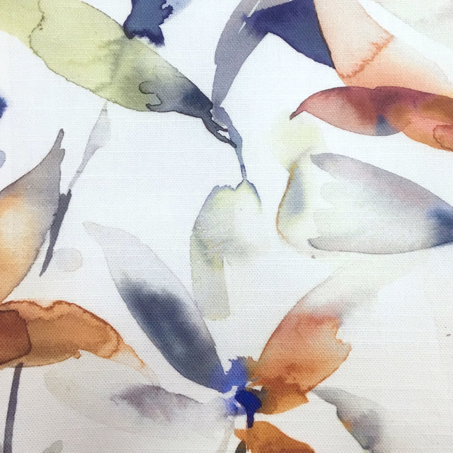 Painterly leaf-print fabric with burnt orange, lilac, blue and olive motifs on white ground