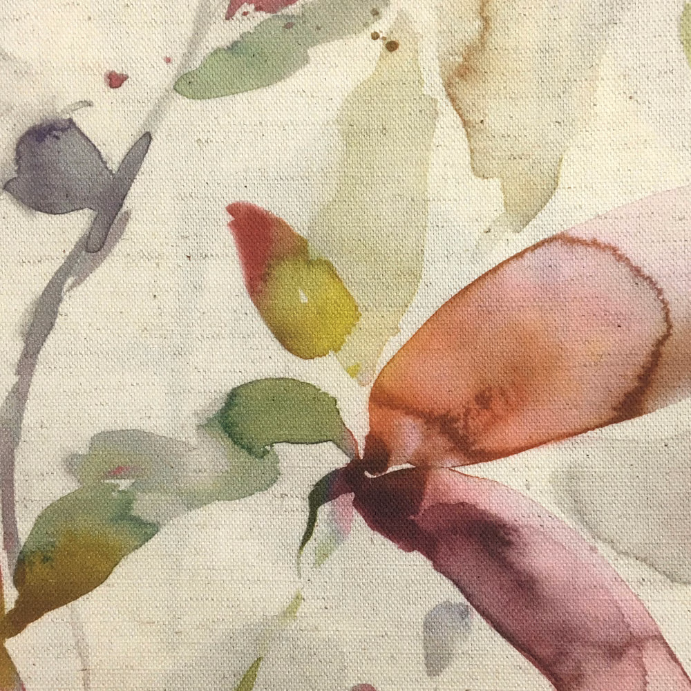 Close-up of a painterly botanical fabric with coral, plum and green leaves on cream ground