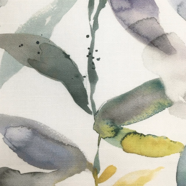 Painterly botanical fabric with muted yellow, sage green and grey leaves on a light ground