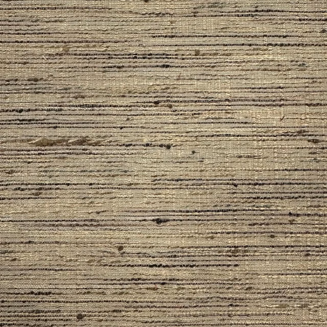 Close-up of warm beige textured fabric with horizontal slubs and dark flecks