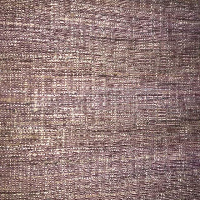 Close-up of muted dusty pink woven fabric with lilac and taupe highlights
