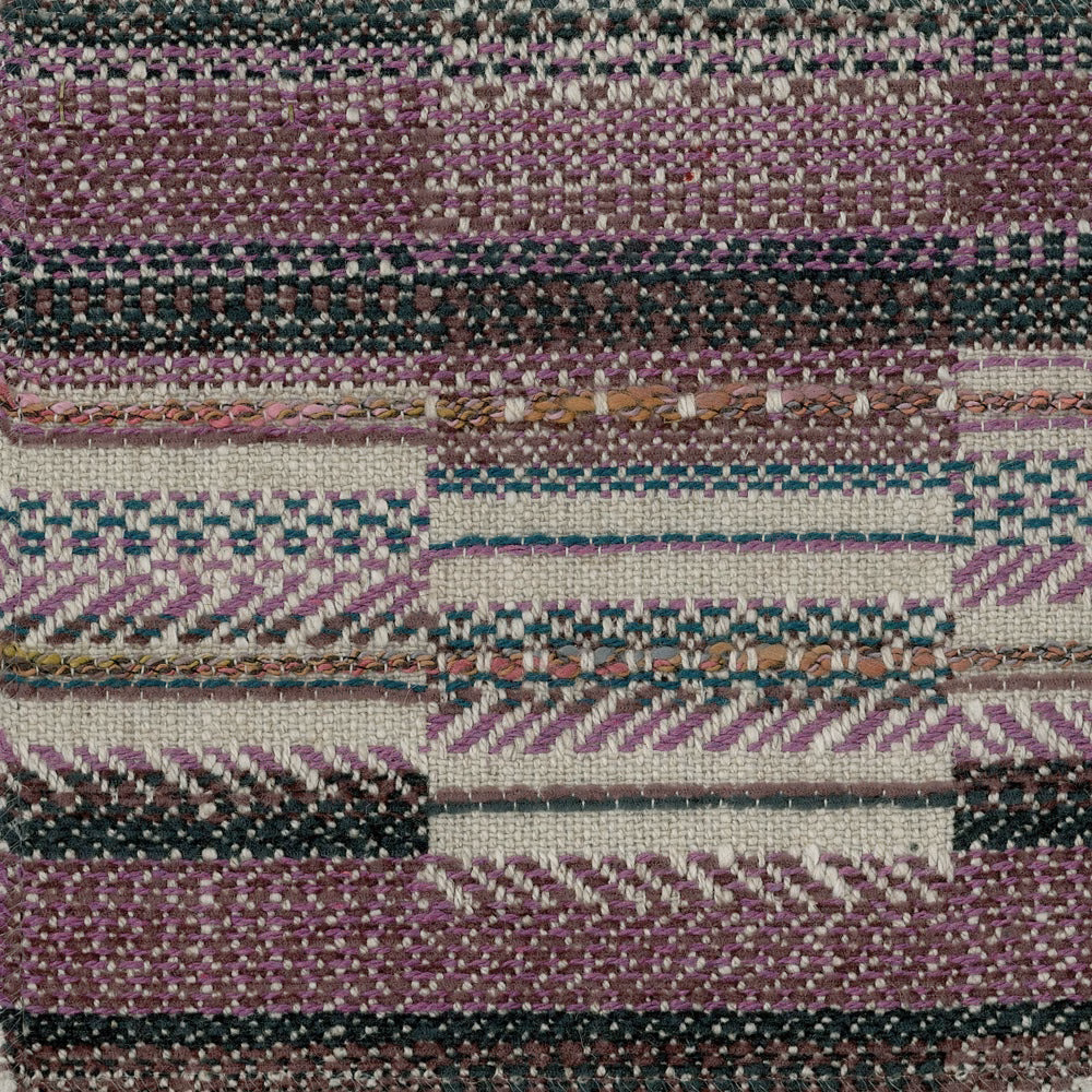 Close-up of a plum purple geometric woven fabric with cream and dark teal accents