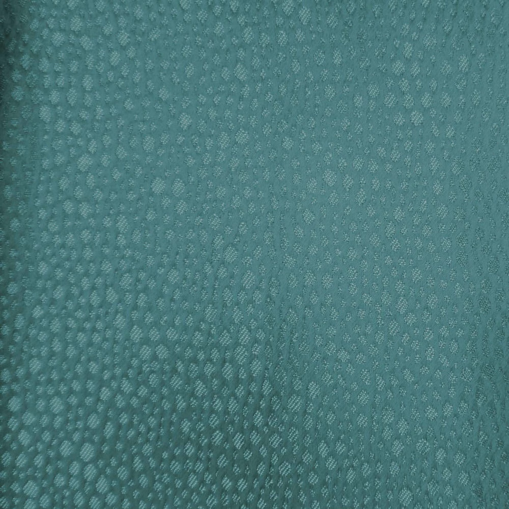 Close-up of muted blue-green teal textured fabric with small dappled weave