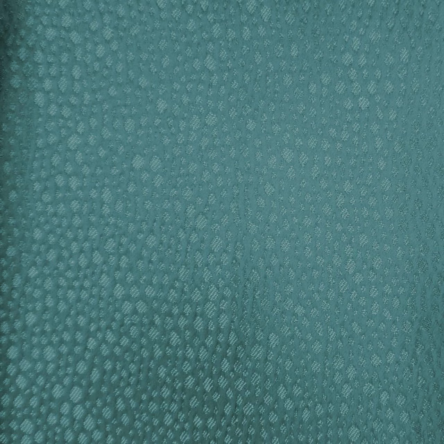 Close-up of muted blue-green teal textured fabric with small dappled weave