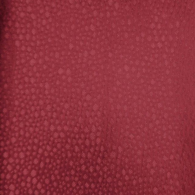 Deep berry red textured fabric swatch with a small woven dappled pattern