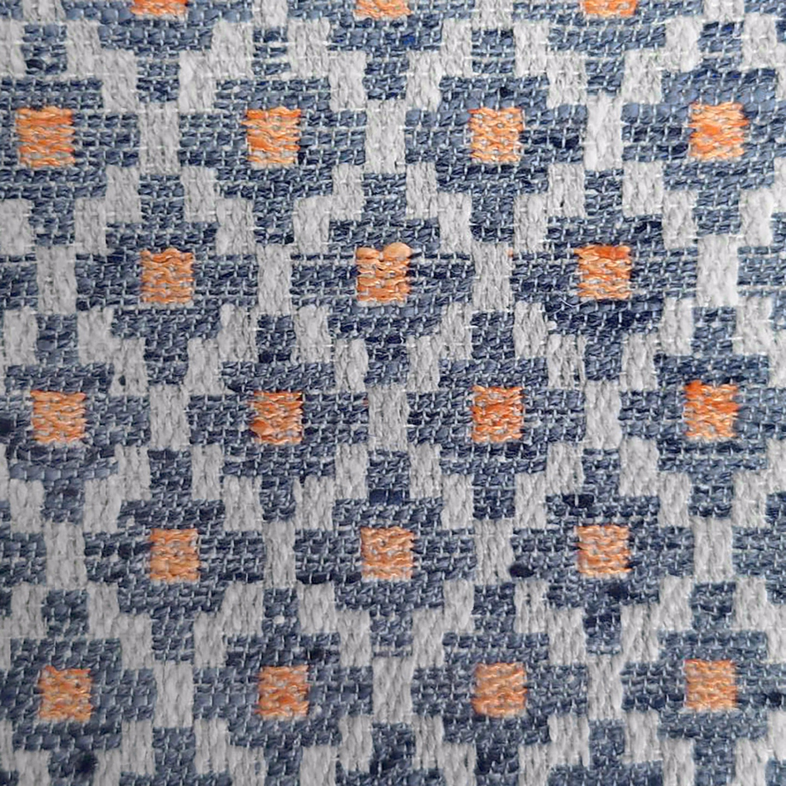 Close-up of a blue and grey geometric woven fabric with orange accents