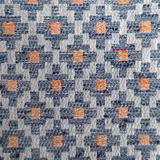 Close-up of a blue and grey geometric woven fabric with orange accents