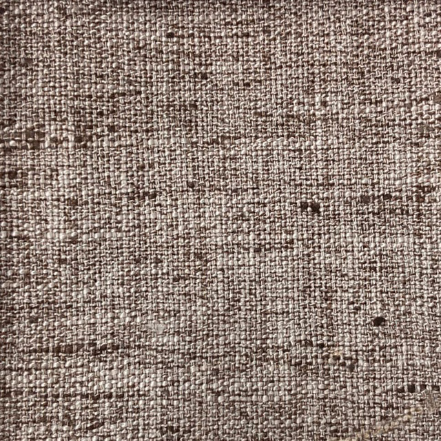 Close-up of warm mushroom-brown woven fabric with subtle flecks and slubbed texture