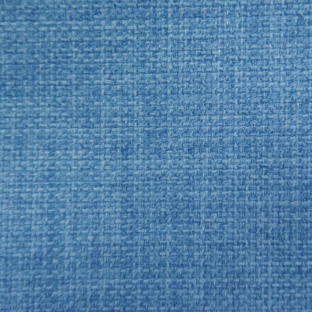 Close-up of soft denim blue woven fabric with fine textured weave
