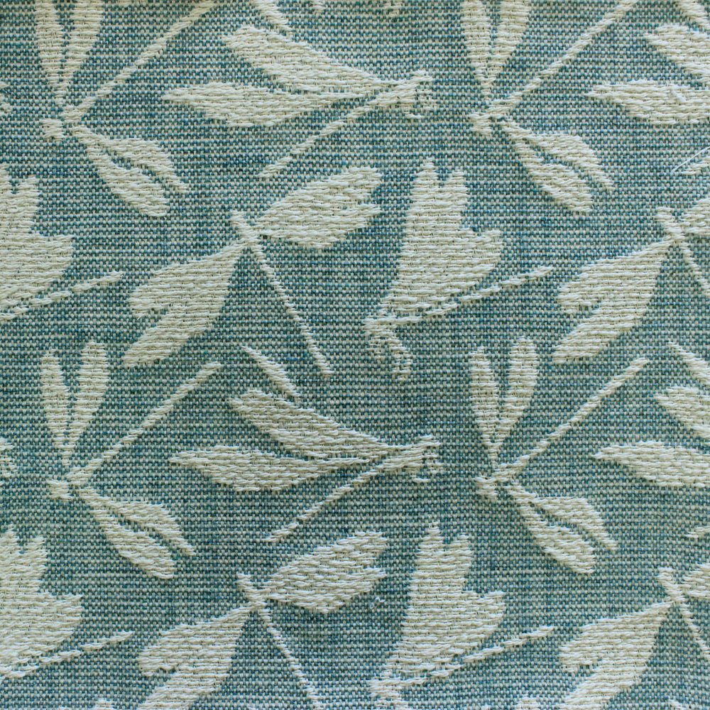 Teal woven fabric swatch with cream leaf motif and textured surface