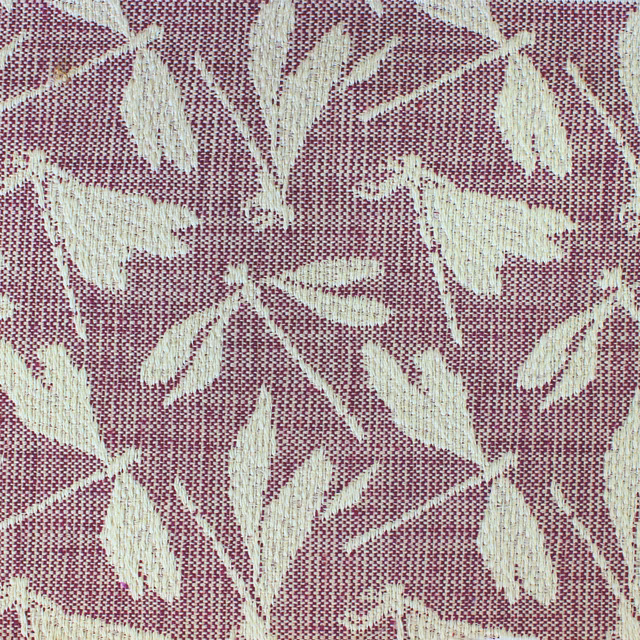 Dusty raspberry pink woven fabric with ivory leaf motif and textured surface