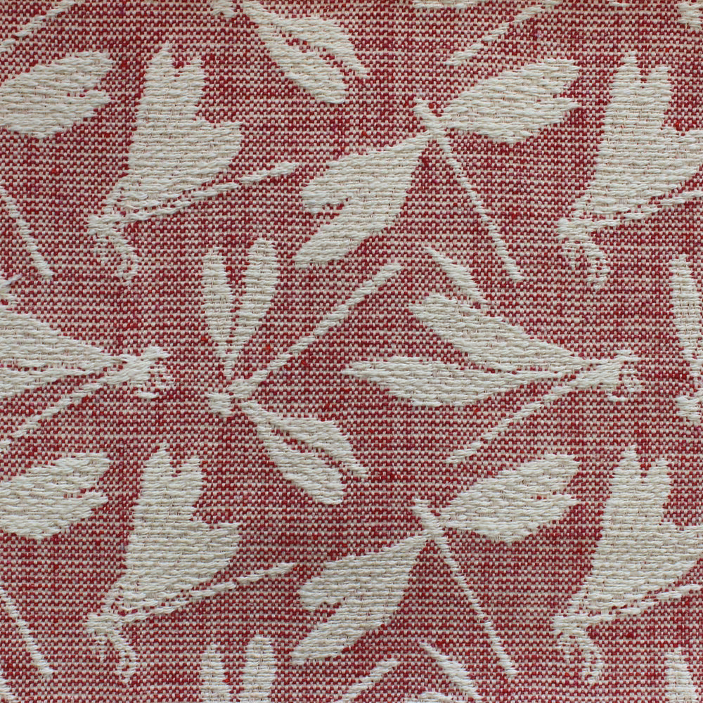 Close-up of red woven fabric with pale leaf motif and textured surface