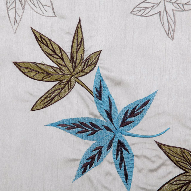 Embroidered aqua and olive leaf motif on a pale neutral fabric ground
