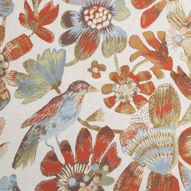 Large-scale floral and bird pattern in warm red, blue and ochre on a pale ground