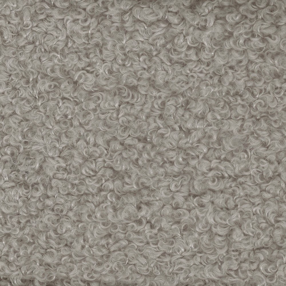 Close-up of warm beige curly boucle fabric with dense looped texture