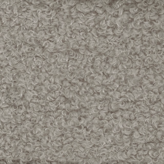 Close-up of warm beige curly boucle fabric with dense looped texture