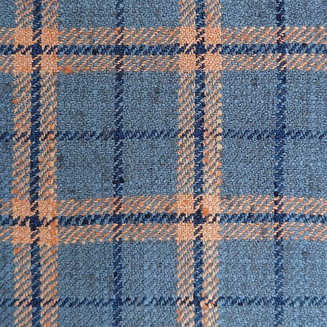 Close-up of a blue and peach checked woven fabric with textured surface