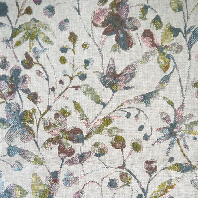 Sage green botanical fabric with trailing leaves and berry-toned details on a pale ground
