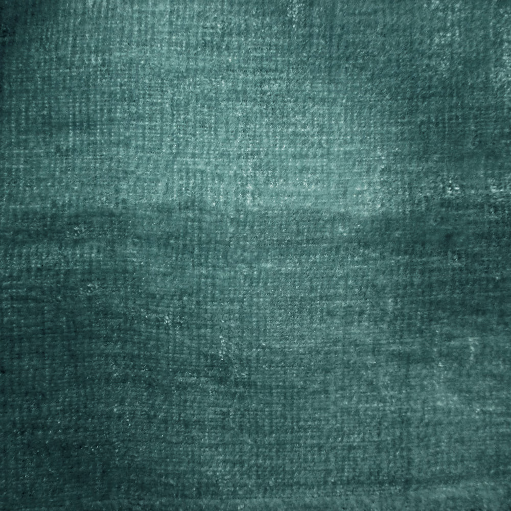 Close-up of deep teal-blue woven fabric with a softly mottled texture