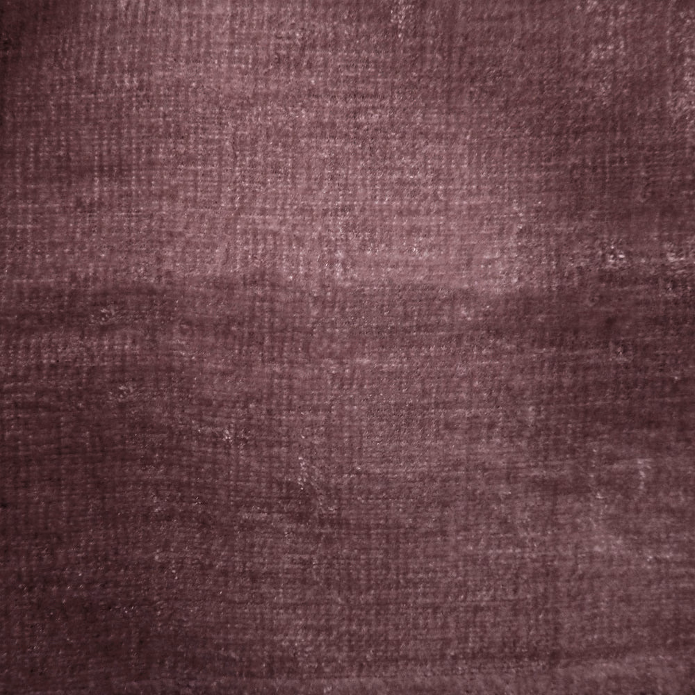 Close-up of deep plum-purple woven fabric with a softly mottled texture