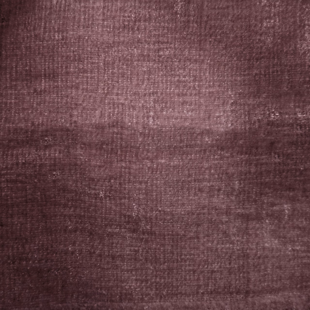 Close-up of deep plum-purple woven fabric with a softly mottled texture