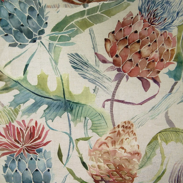 Painterly floral fabric with terracotta orange blooms and green leaves on a pale ground