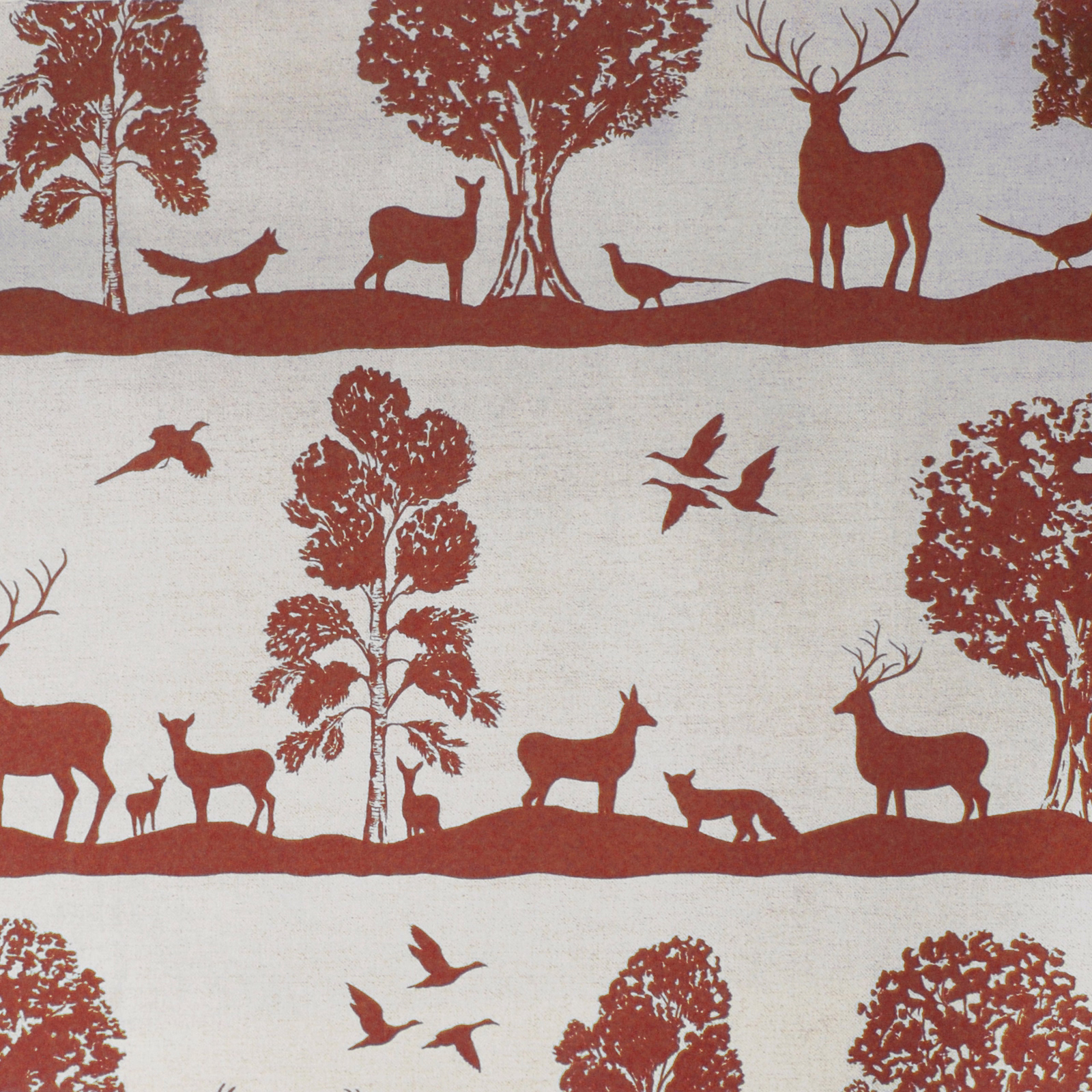 Terracotta red woodland deer and tree print on a pale linen-cotton fabric