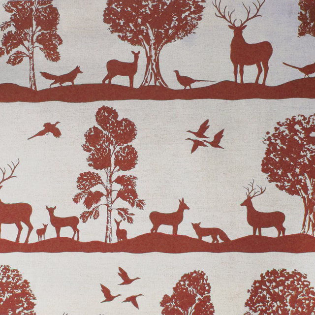 Terracotta red woodland deer and tree print on a pale linen-cotton fabric