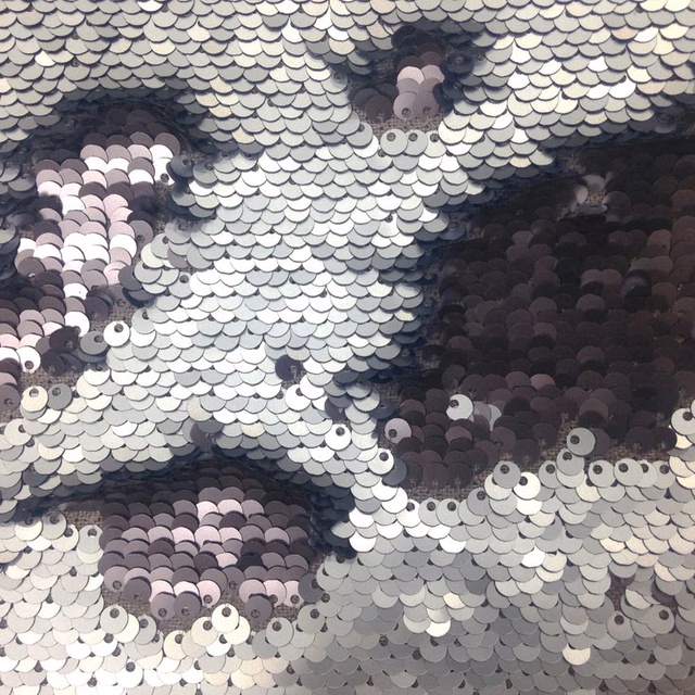 Close-up of smoky purple sequin fabric with overlapping silver and plum discs